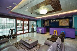 a lobby with purple walls and a table and chairs at Lily Hotel in Kaohsiung