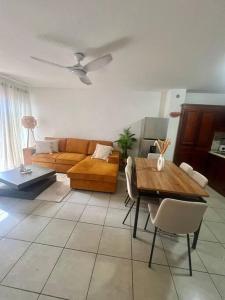 a living room with a couch and a table at Beau T2 en Rez de jardin in Saint-Denis