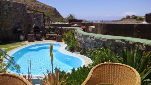 a swimming pool in a yard with two chairs at Bungalow 21 Tauro in La Playa de Tauro