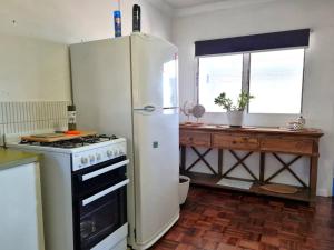 une cuisine avec un réfrigérateur blanc et une fenêtre dans l'établissement Crab Claw Cottage, à Port Broughton 15 autres photos