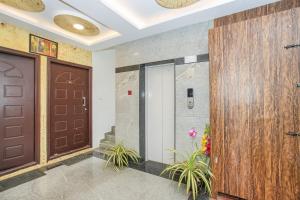 a lobby with two brown doors and plants at Collection O Royal Mac in Bangalore