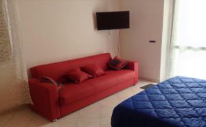 a red couch in a living room with a bed at Casa Martina in Pescara