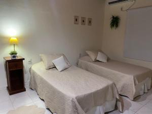 a room with two beds and a table with a lamp at Oc temporarios in Paso de los Libres +10 photos