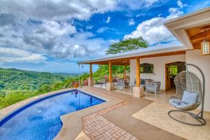 a home with a swimming pool and a patio with a table and chairs at The Retreat at Blue Mountain Farms in Sámara