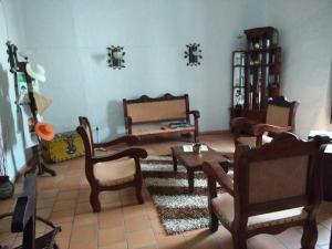 サン・ヒルにあるCasa HOTEL EL MARQUEZのリビングルーム(木製の椅子、テーブル付)