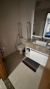 a bathroom with a sink and a toilet at Apartamento linda vista no Brisas do Lago, Brasília in Brasilia