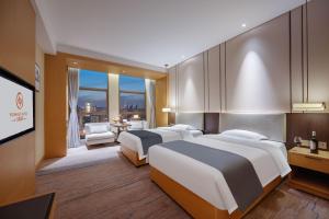成都Chengdu Yunhao High-altitude Hotel的一间有两张床和一台平板电视的酒店房间