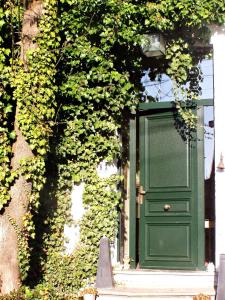 une porte verte sur le côté du bâtiment dans l'établissement B&B Le Bonimenteur, à Charleroi