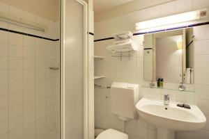 een witte badkamer met een toilet en een wastafel bij Les Lilas Serviced Apartments in Les Lilas +30 foto's