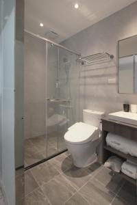 un bagno con wc e doccia in vetro di Tango Inn Taipei Kaifong a Taipei