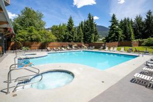 a large swimming pool with chairs around it at Newly Renovated KING BED STUDIO in the Village in Whistler +8 photos