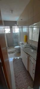 a bathroom with a sink and a toilet and a mirror at Sobrado com piscina Itapoá in Itapoa