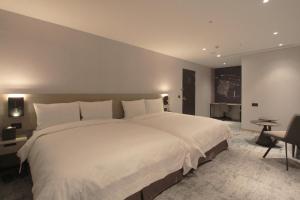 una grande camera da letto con un grande letto bianco di Tango Inn Taipei Kaifong a Taipei