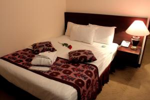 a hotel room with a bed with a lamp and towels at Hotel Uzbekistan in Tashkent