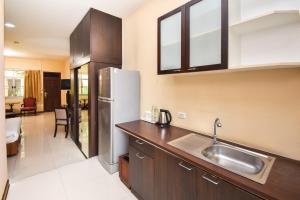 a kitchen with a sink and a stainless steel refrigerator at Piman Garden Boutique Hotel in Khon Kaen