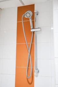 a shower with a hose hanging on a wall at Piman Garden Boutique Hotel in Khon Kaen +44 photos