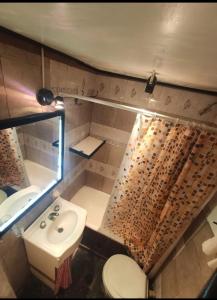 a small bathroom with a sink and a toilet at Casa Gesell in Villa Gesell +8 photos