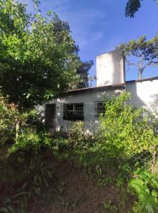 an old white building with trees in front of it at Casa Gesell in Villa Gesell