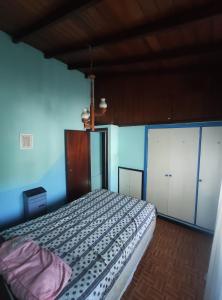 a bedroom with a bed and a blue wall at Casa Gesell in Villa Gesell