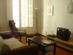 a living room with a couch and a tv at AApartments in city center in Barcelona