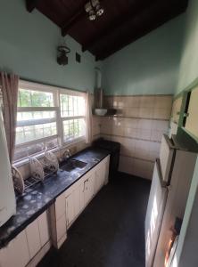 an empty kitchen with a sink and a window at Casa Gesell in Villa Gesell