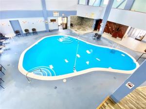 a large pool in a room with chairs and tables at Stringer's Peak Retreat in Beech Mountain