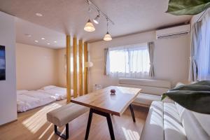 un soggiorno con un tavolo e un divano di COZY FUJI VIEW Stay a Fujikawaguchiko