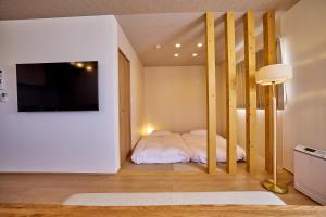 una camera da letto con un letto e una TV a schermo piatto di COZY FUJI VIEW Stay a Fujikawaguchiko