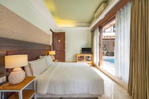 Un dormitorio con una cama y una ventana grande. en Cove The Ricks Villa, en Canggu