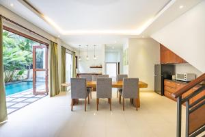 cocina abierta y comedor con mesa y sillas en Cove The Ricks Villa, en Canggu