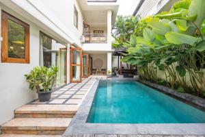 una piscina en el patio trasero de una casa con plantas en Cove The Ricks Villa, en Canggu 30 fotos más