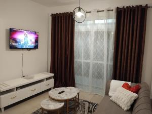 a living room with a couch and a tv at Millan home stay Nyali in Mombasa