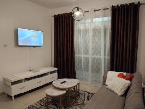 a living room with a couch and a flat screen tv at Millan home stay Nyali in Mombasa
