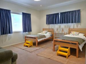 una camera con due letti e tende blu di Tidal Life a Wool Bay