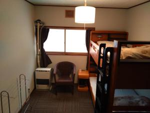 a bedroom with a bed and a chair and a window at Mountain Jam in Kutchan