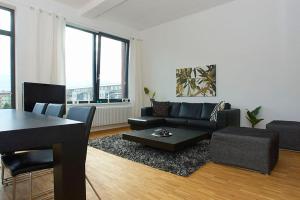 a living room with a black couch and a table at Spacious Studio Apartment Friedrichshain in Berlin