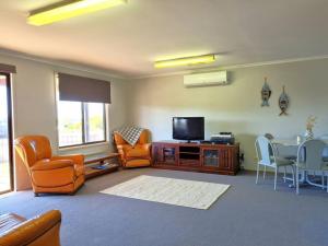 a living room with a tv and a table and chairs at Wilgra By The Beach in Wauraltee