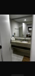a bathroom with a sink and a mirror at Granja Brasil Flat Itaipava in Araras Petropolis +4 photos