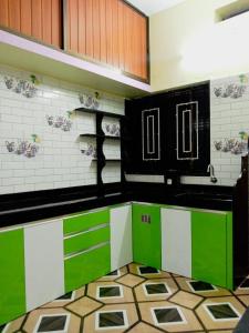 HonāvarVian Homestay的厨房配有绿色和白色的柜台和橱柜