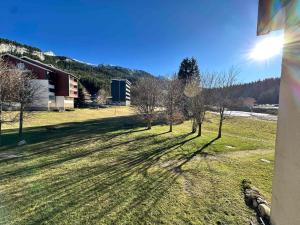 un gruppo di alberi in un campo con un edificio di Studio cosy au pied des pistes, balcon sud, parking - FR-1-515-221 a Corrençon-en-Vercors Altre 2 foto