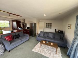 a living room with a couch and a table at The Iron Gate Family Hideaway - Pet Friendly in Cromwell