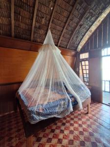 a bed with a net on it in a room at Koridek Homestay in Friwin