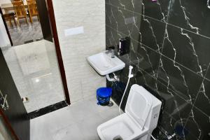 a bathroom with a white toilet and a sink at Village Villa Agra in Tājganj