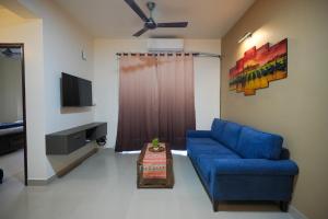 瓦尔恰1 BHK Near Varca Beach的客厅里有一张蓝色沙发和一台电视