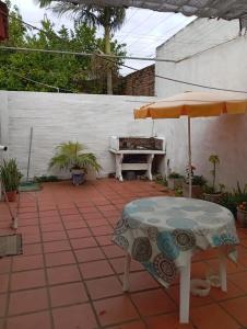patio con tavolo, ombrellone e pianoforte di Casa Alberdi a Colón