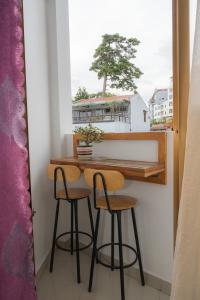 un tavolo e due sgabelli in una stanza con finestra di Khanh Hong Da Lat a Da Lat