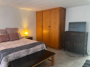 um quarto com uma cama e uma cômoda com uma televisão em 50 on Cap em Bloemfontein