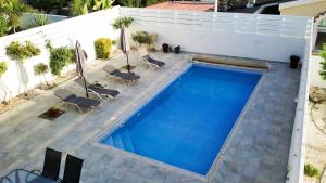 an overhead view of a swimming pool with chairs at Marios Villa in Larnaca