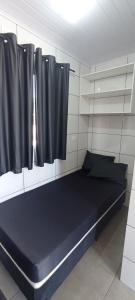 a room with a large bed with black curtains at Vila Foz HOSTEL AP8 Apartamento completo de casal com ar condicionado, garagem fechada e lavanderia, Temos Uber e guia turístico para indicar, nosso apartamento é o melhor custo benefício de Foz do Iguaçu in Foz do Iguaçu