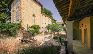 a stone building with a bench in a courtyard at Les Carmes and spa in Le Thor